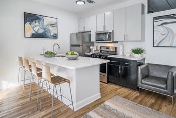 A modern kitchen with a white island and black appliances.at Iris Luxury Apartments, Memphis, 38105  